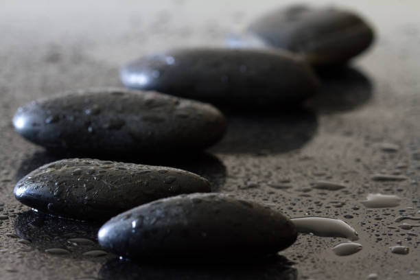 Dewy stones on black background, spa concept, body and mind, zen stone massage