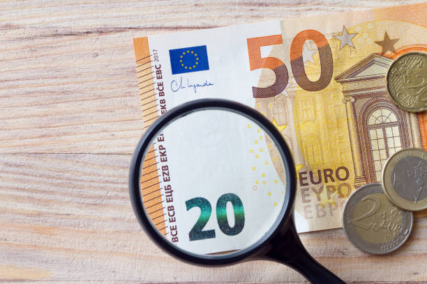 インフレの概念。貨幣価値の低下、虫眼鏡下のユーロ紙幣 - magnification coin equipment european union currency ストックフォトと画像