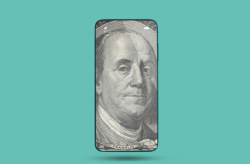 tocurrency and modern banking. Picture of Benjamin Franklin in smartphone at a turquoise background. The concept of the cyberspace, stock exchange and finance.