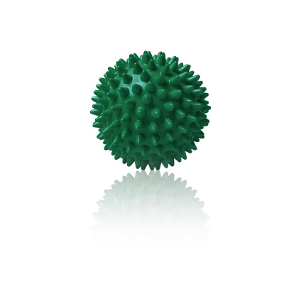 Green plastic spiny massage ball isolated on white. Concept of physiotherapy or fitness. Closeup of a colorful rubber ball for dog teeth on a white color background. Corona virus model.
