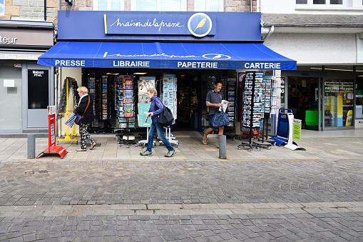 Erquy, France, June 24, 2022 - People infront of the Press House / Bookstore, a store for stationery, toys, newspapers, magazines, books, and cartoons in the centre of Erquy