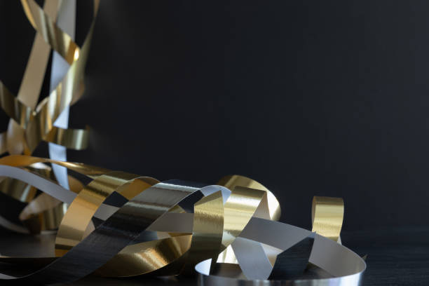 istock Silver and gold shiny streamers on black 1409127760