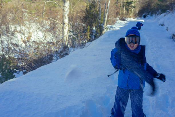 istock boy throwing snowball while hiking with his family 1409127843