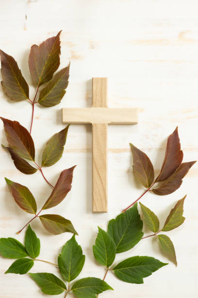 istock Wood cross with autumn leaves on white 1409131020