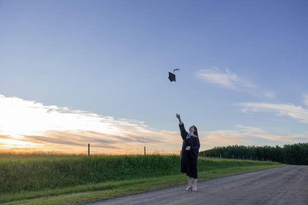 Graduate cap throw on rural road stock photo