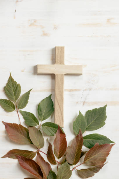 istock Cross and red and green leaves on white 1409131029