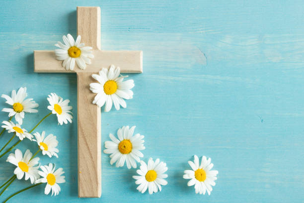 istock Wood cross with daisies on blue 1409131197