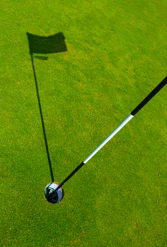 Sports Image Of A Hole On A Golf Course With The Shadow Of The Flagstick