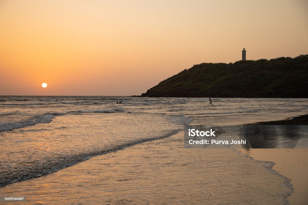 Lighthouse and sunset at Achara Beach, Sindhudurga, Maharashtra. Achara beach located in Achara, Malvan is a beach with a view to die for! on your right is a hill on which is situated the Achara Lighthouse. Arabian Sea Stock Photo