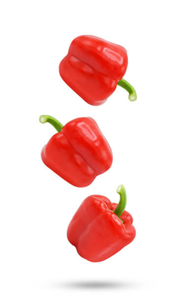 istock Whole red bell pepper falling in the air isolated on white background. 1409135790