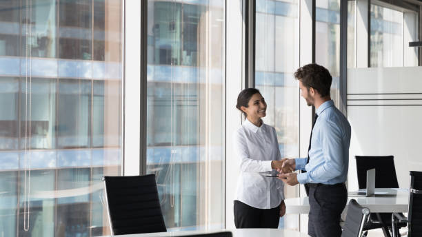 Multi ethnic client and manager make deal, handshaking, express respect stock photo