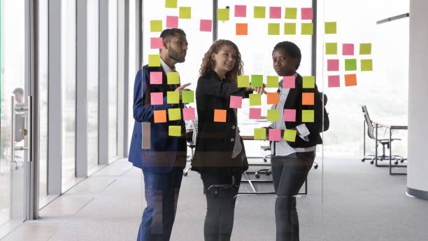 Leader of project explain to teammates information on sticky notes