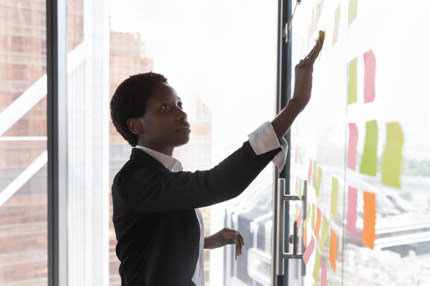 istock African businesswoman prepare tasks on sticky notes attaching on wall 1409137559