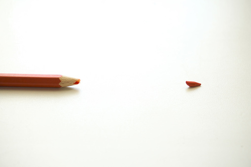 Red pencil on a white background. Broken pencils tip, chancellery, school supplies.