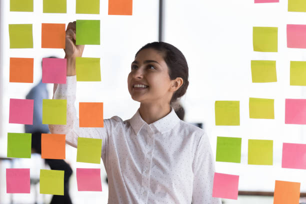 istock Indian employee jotting information and reminders on sticky notes 1409139856