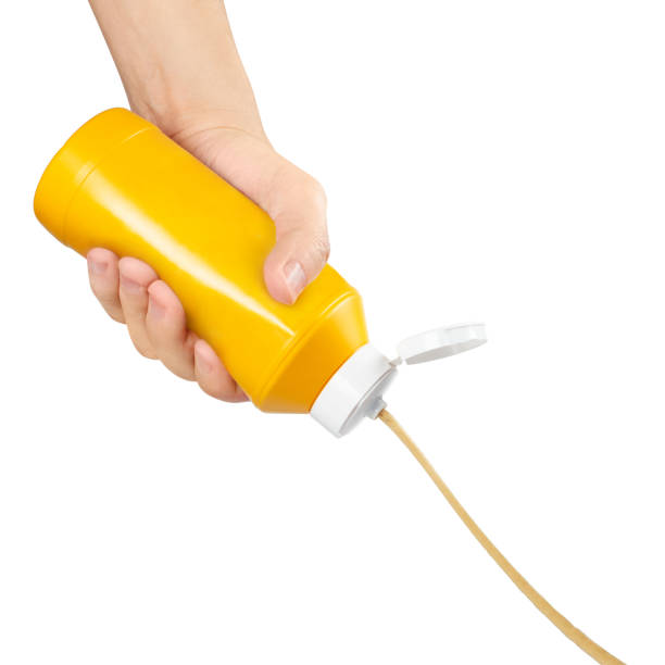 istock Hand squeezing mustard out of a plastic bottle on white 1409140741