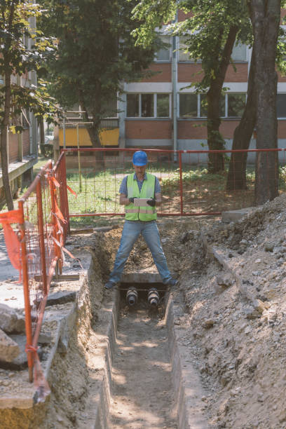 istock Technician inspecting heating pipeline trench in the city 1409141611