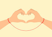 istock Two hands tied with the red thread of fate showing a heart sign. Vector illustration 1409142486