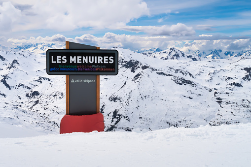 Les Menuires, France, April 5 2022, signpost to luxury town les menuires in skiing area trois valles translation: three valleys, horizontal shot shot
