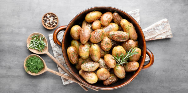 istock Pan filled with roasted potatoes shot on rustic wooden table. 1409144725