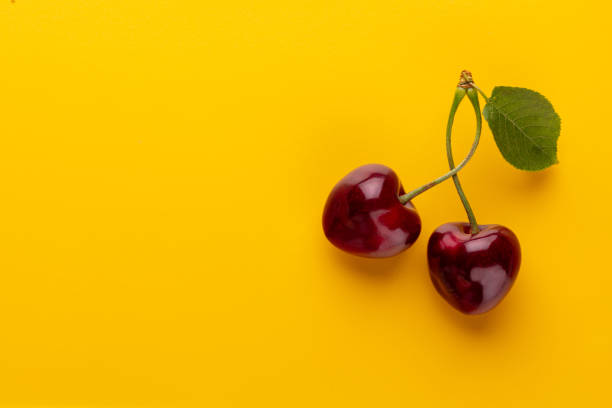 istock Cherry berries on a pastel background top view.  Background with a cherry on a sprig, flat lay 1409148789
