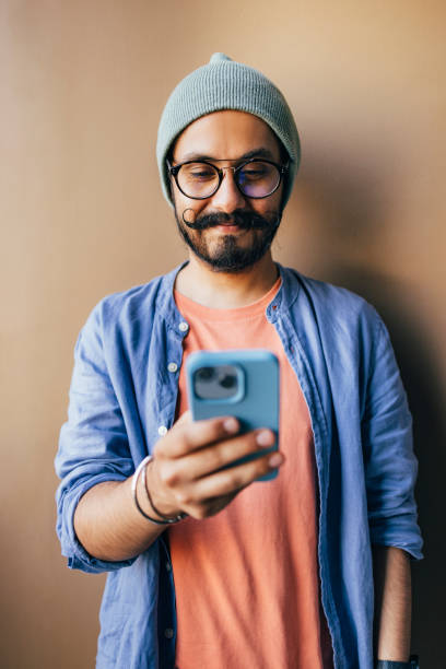 istock A Happy Casually Dressed Freelancer With Glasses Texting On His Mobile Phone 1409150752
