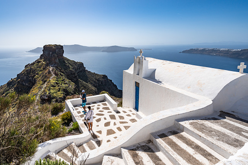 Traditional white Greek church with an amazing view over Sakros rock in Santorini. Imerovigli, Santorini, Greece, Apr. 2022