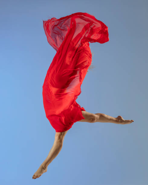istock Dancer jump on blue background with red fabric 1409154507
