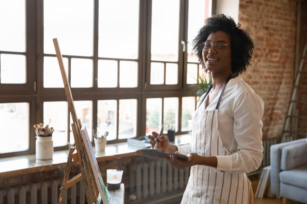 istock African female artist drawing picture on canvas pose for camera 1409155390