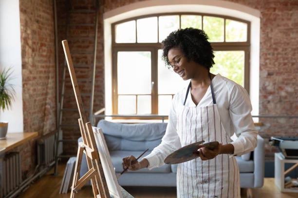 istock African woman painter holding palette painting on canvas in workshop 1409155394
