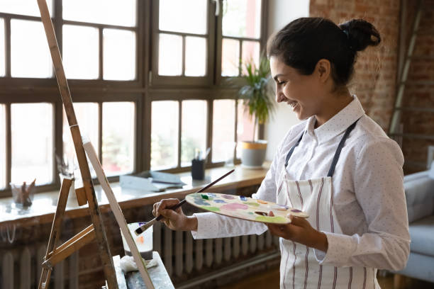 istock Indian painter woman practices painting on canvas with paints 1409155407