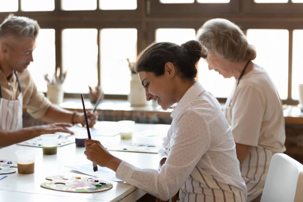 istock Multiracial painters engaged in painting art class in modern workshop 1409155428