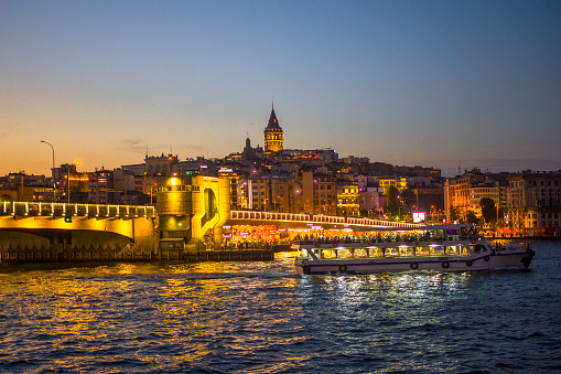 Galata Tower, the historical and touristic symbol of Istanbul. Eminonu district with many facilities to eat such as floating restaurants and carts with fresh bakery, hot corn or roasted chestnuts in Istanbul, Turkey.