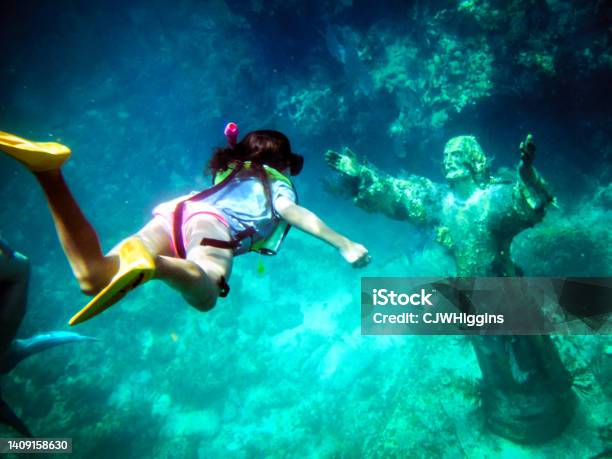 Girl Snorkeling To Christ Of The Abyss Statue Off Key Largo Florida Gulf Of Mexico Stock Photo - Download Image Now
