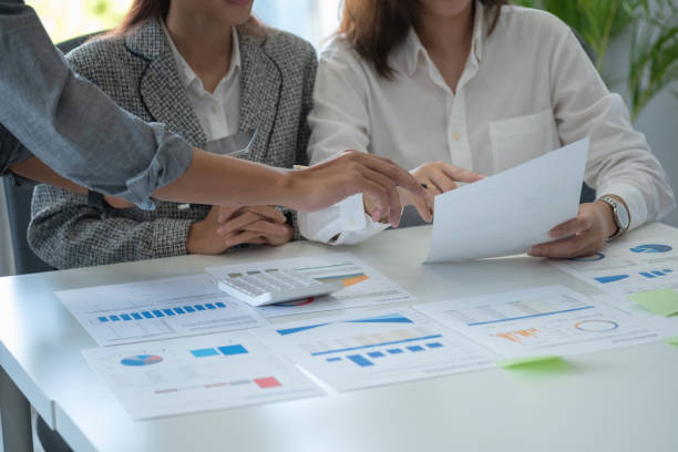 istock Team of business use calculators and graph analysis computer laptop tablets to plan marketing strategies and make profitable investments for the company. 1409158776
