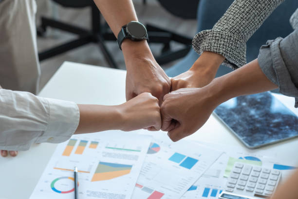istock Company representatives join hands to work together on real estate projects and make profits for the company. 1409166130
