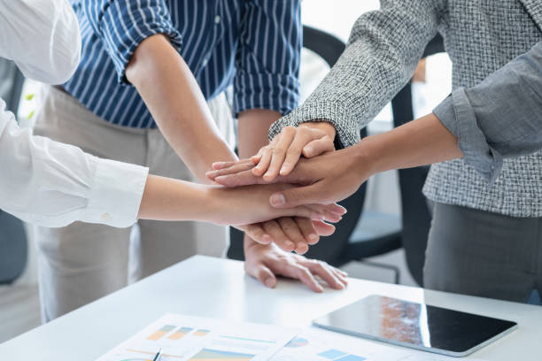 istock Company representatives join hands to work together on real estate projects and make profits for the company. 1409166152