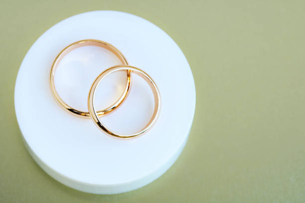 istock Two wedding rings on a white podium, top view. 1409169469