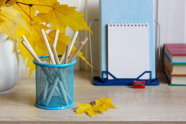 Back to school background with yellow maple leaves. Stationery on the table.