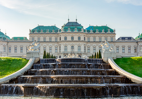 Vienna, Austria - October 2021: Cascade fountain with ancient sculptures and Upper Belvedere palace in Vienna