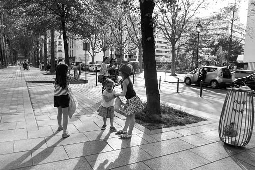 05-06-2016 Paris, France. Girls playing in district near Le Bassin de la Villette in Paris and Quai Valmy  - sunset and Mayю Mothers behind