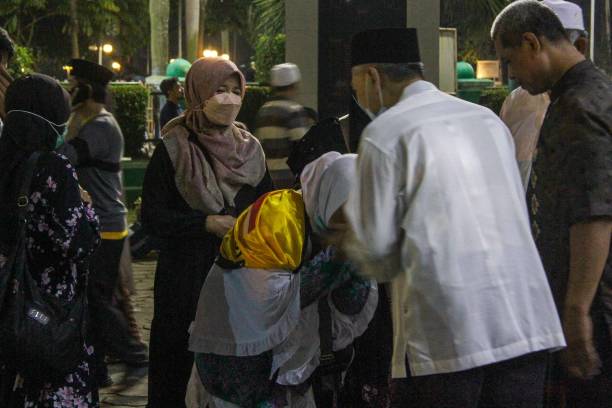 The Arrival of Indonesian Hajj Pilgrims Tears of joy broke out when the Pilgrims of the First Kelloter Hajj of Banten Province arrived at the Tangerang City Government Center. Family members who have been waiting since 09.00 pm have finally been able to meet their relatives who have just completed the fifth Pillar of Islam worship at 01:30 am in the morning. Seen seen the pilgrims were carrying luggage bags walking to meet the family who picked him up. Sunday. July 17, 2022. malay couple full body stock pictures, royalty-free photos & images
