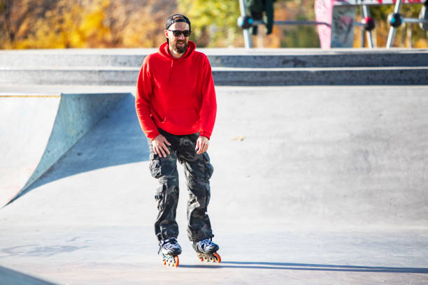 Middle age man roller skating in skateboard park