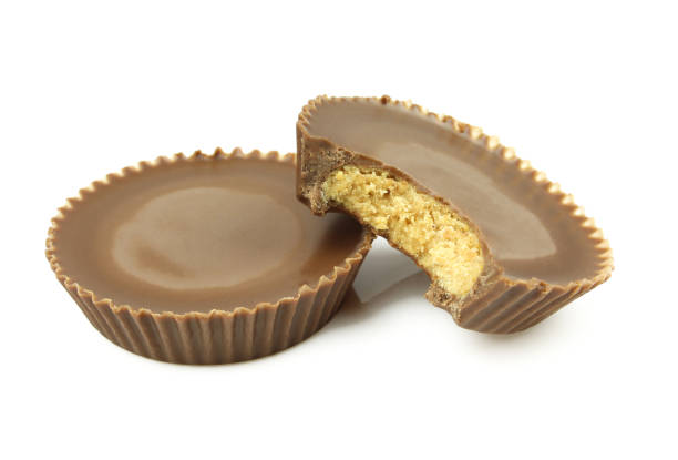 Short cupcake shaped sweets with peanut filling and chocolate cover. Bitten and isolated on white background