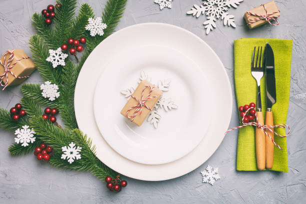 istock Christmas table place setting with christmas decor and plates, kine, fork and spoon. Christmas holiday background. Top view 1409177383