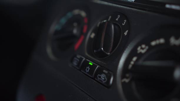 the woman turns on the fan and presses the air conditioner button in the car. automotive panel close-up. - car air conditioner vehicle interior driving imagens e fotografias de stock