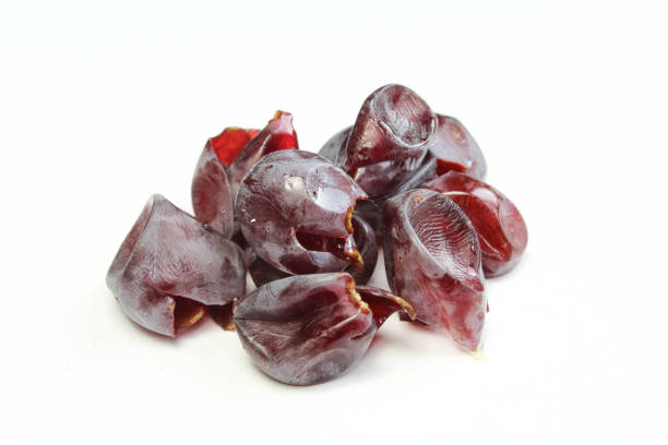 mucchio di buccia d'uva scura isolata su fondo bianco. buccia d'uva macro - dried grape foto e immagini stock