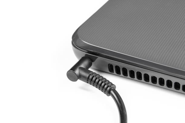 istock Electricity charging black laptop isolated on white background. Closeup 1409181105