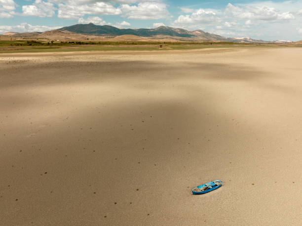 aerial view of a fishing boat on a drought dry lakebed. - lakebed imagens e fotografias de stock