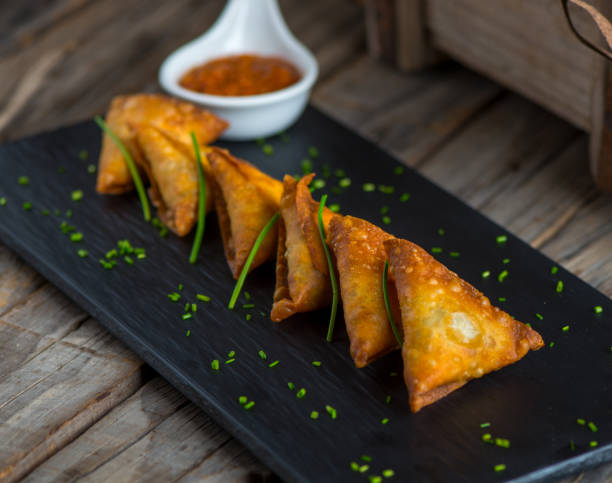 samboosa or samosa with ketchup served in a dish isolated on wooden background side view of appetizer stock photo